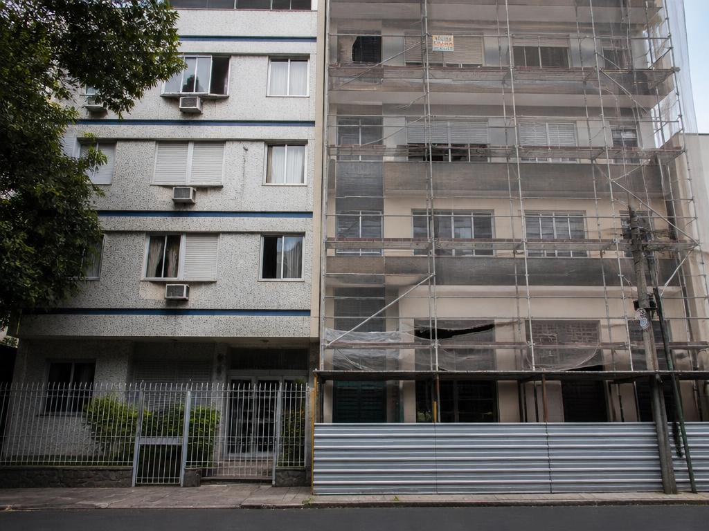 Edifício residencial com andaime ao lado de imóvel vizinho, cenário típico de cautelar de vizinhança